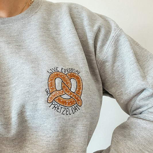 Buzo bordado live everyday like pretzel day the office